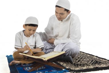 Çocuk ve babası birlikte Kur'an okuma