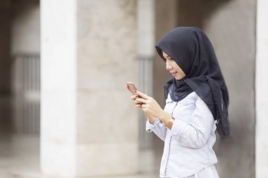 Bir akıllı telefon kullanan güzel Müslüman kadın