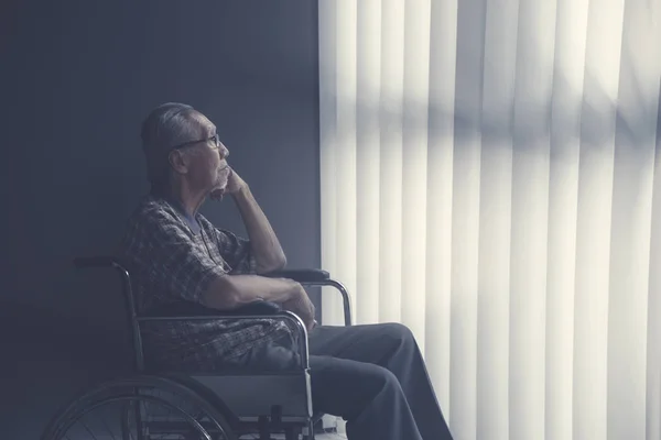Triste uomo anziano solitario seduto sulla sedia a rotelle — Foto Stock