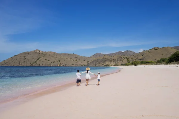 Matka i dzieci spaceru na plaży różowy — Zdjęcie stockowe