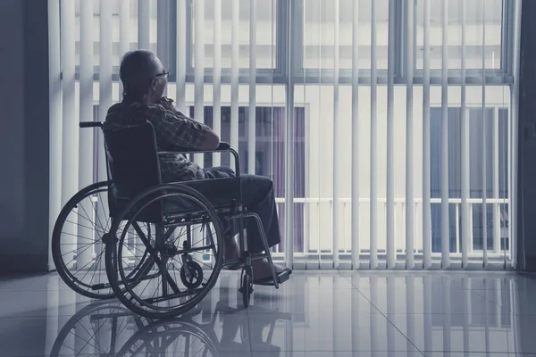 Lonely old man sitting on wheelchair at home — Stock Photo, Image