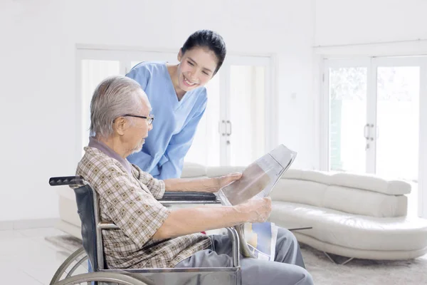 Female nurse talking with old man at home — Stock Photo, Image
