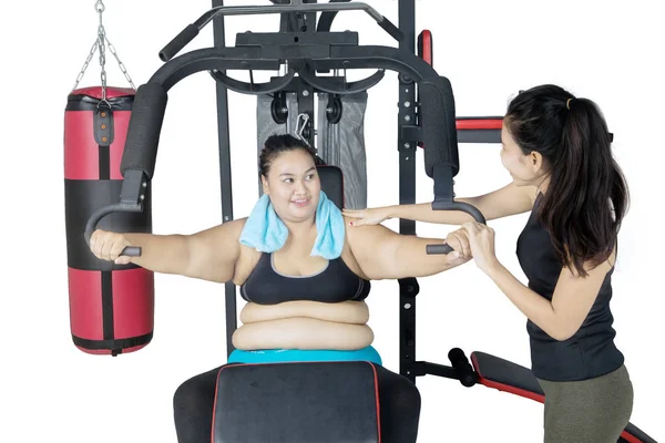 由训练师帮助的肥胖妇女锻炼 — 图库照片