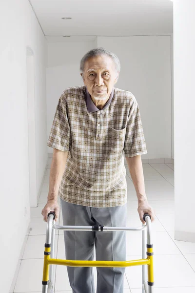 Ηλικιωμένος άνδρας περπάτημα με έναν περιπατητή στο σπίτι — Φωτογραφία Αρχείου