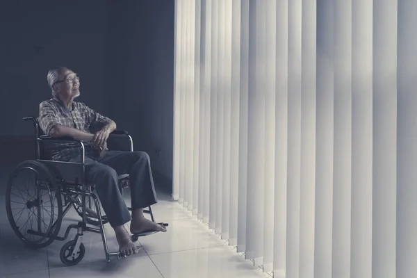 Homme âgé assis en fauteuil roulant — Photo