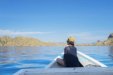 Woman enjoying Padar Island view from boat clipart