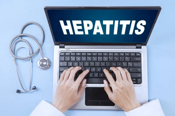 Okänd läkare med hepatit word och laptop — Stockfoto
