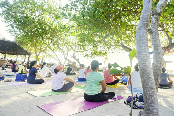 Toeristen uitoefening van yoga op het strand van Sanur — Stockfoto