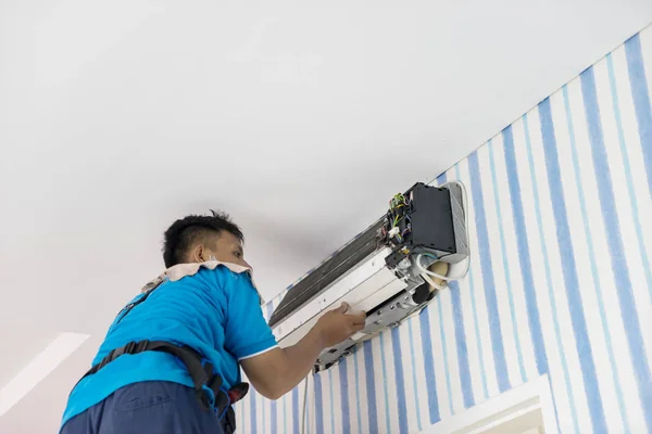 Male technician repairing an air conditioner — Stock Photo, Image