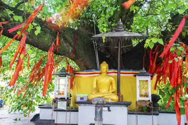 Golden Buddha sculpture with red Chinese talisman — Stock Photo, Image