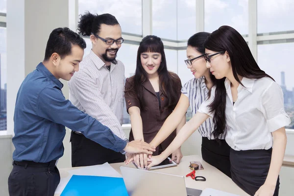 Equipe de negócios unindo as mãos na sala de reuniões — Fotografia de Stock