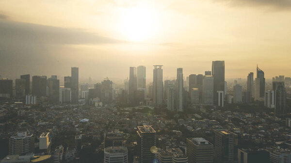 Bird view of beautiful sunset above skyscrapers and residential house in Jakarta, Indonesia
