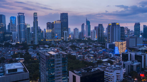 Aerial scenery of beautiful Jakarta city with skyscrapers and residential buildings at dusk