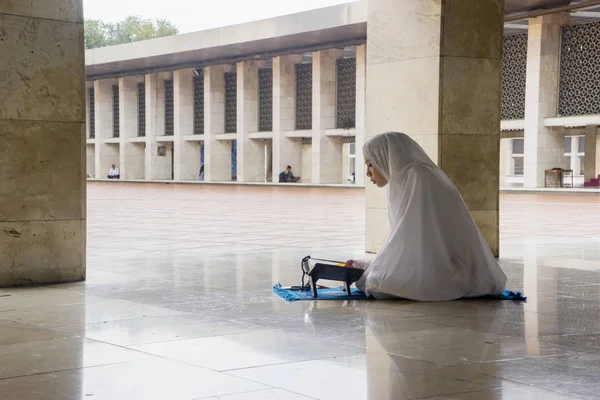 Asian woman reading Quran in the Istiqlal mosque — Stock Photo, Image