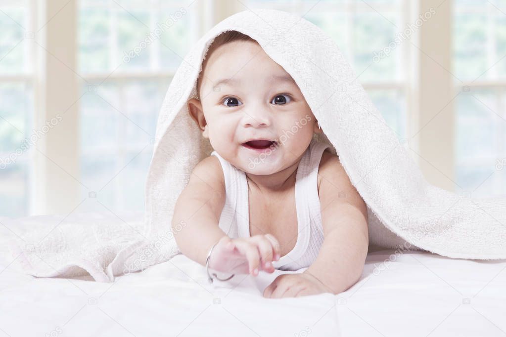 Joyful baby boy in the bedroom