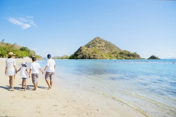 Familia joven caminando por la playa tropical —  Fotos de Stock