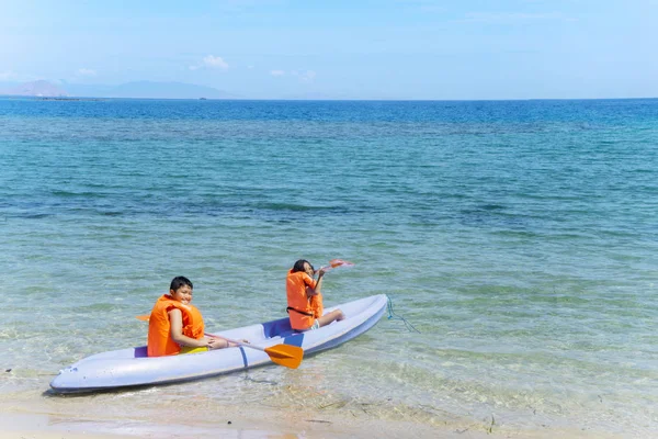 Two siblings kayaking on the beach — Stock Photo, Image