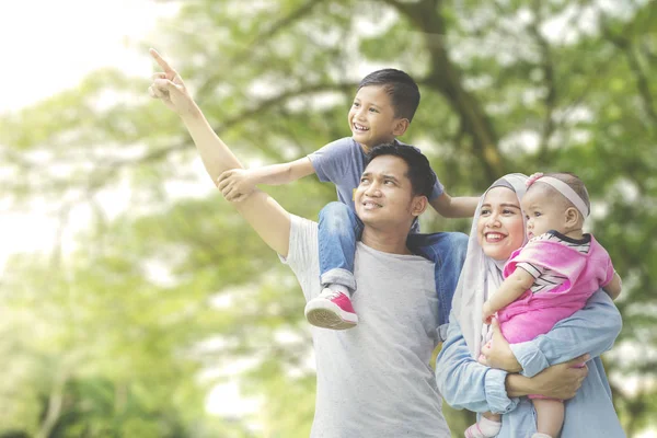 Família muçulmana olhando para algo no parque — Fotografia de Stock