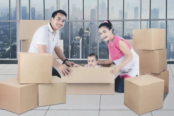 Unga asiatiska familjen ha roligt uppackning lådor — Stockfoto