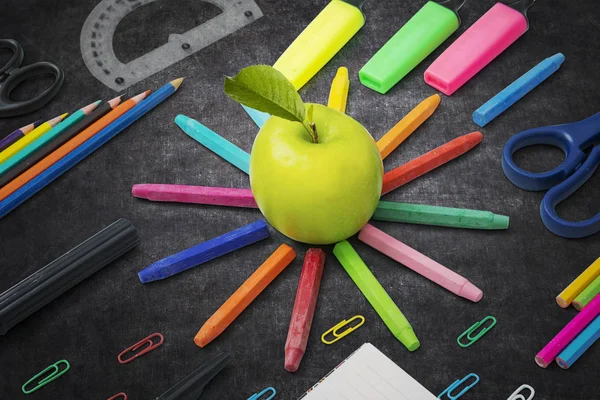 Manzana verde con útiles escolares en la pizarra — Foto de Stock