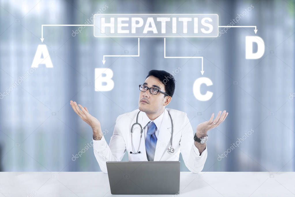 Pensive doctor looking at hepatitis word