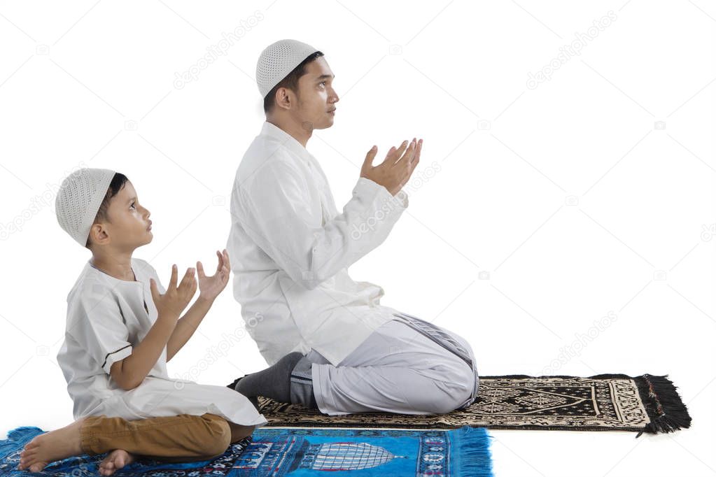 Father with child praying together on studio