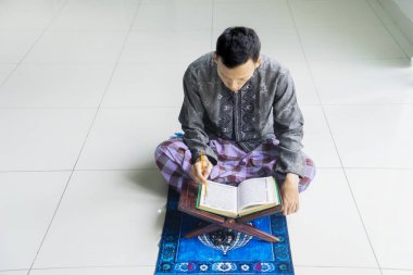 Dindar Müslüman adam Kuran okuyor.