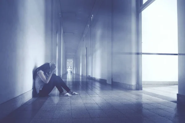 Молода жінка плаче в коридорі — стокове фото