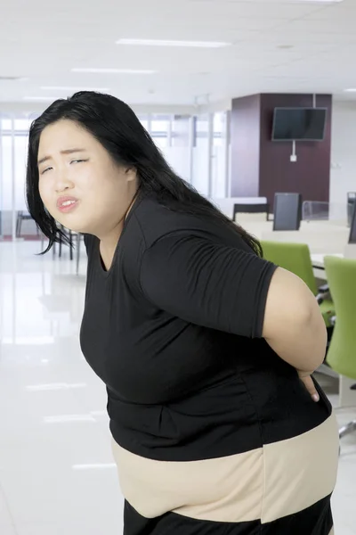 Obese businesswoman having a backache — Stock Photo, Image