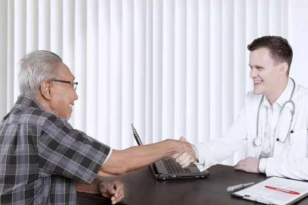 Male doctor shaking hands with his patient — Stock Photo, Image