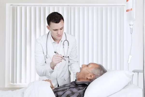 Lékař zkoumá jeho pacienta v pooperačním pokoji — Stock fotografie
