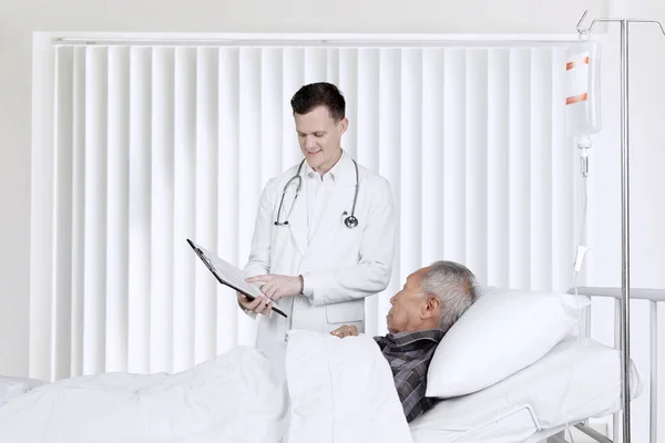 Arzt und Patient mit Klemmbrett im Aufwachraum — Stockfoto