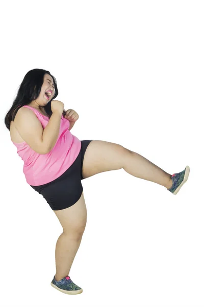 キックを実行する若い肥満女性 — ストック写真