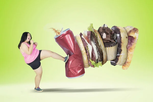 Junge übergewichtige Frau tritt gegen Junk Food — Stockfoto