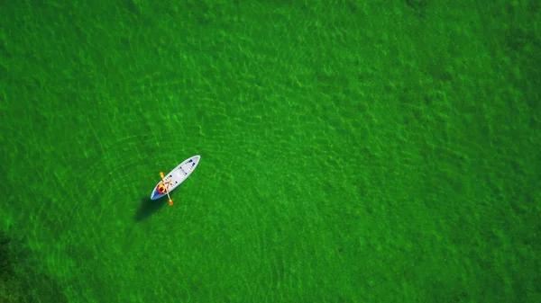 Молодий чоловік катається на каное на бірюзовій морській воді — стокове фото