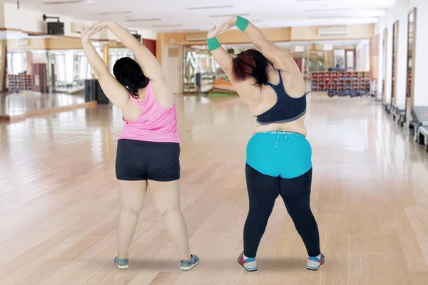 Dos mujeres con sobrepeso estirando las manos juntas —  Fotos de Stock