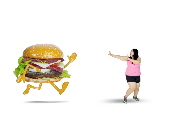 Mulher com excesso de peso foge de um hambúrguer — Fotografia de Stock