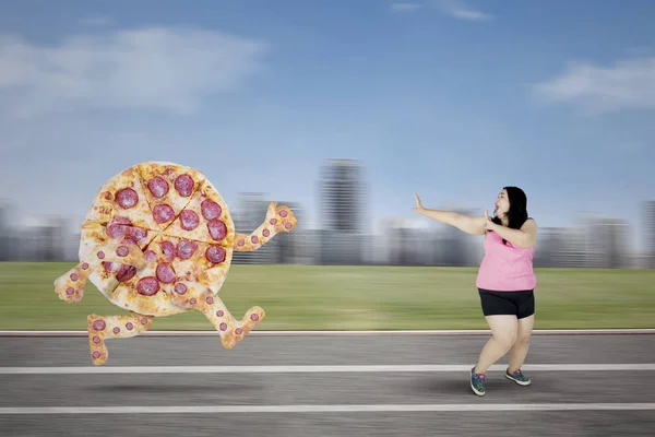 Υπέρβαρη γυναίκα τρέχει μακριά από μια πίτσα — Φωτογραφία Αρχείου