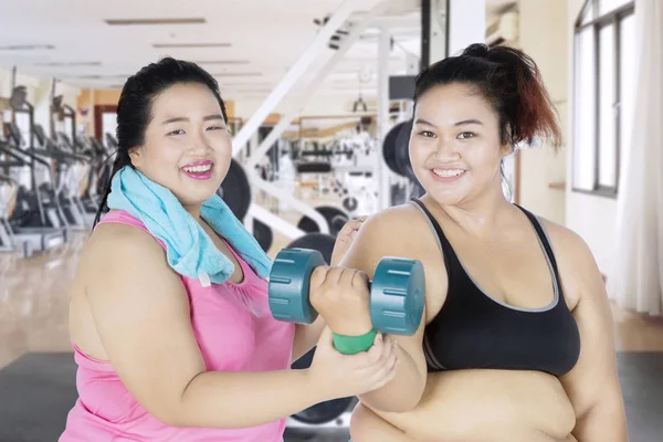 Overweight woman helps her friend to workout — Stock Photo, Image