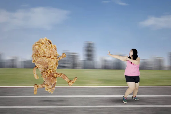 Obez kadın kızarmış tavuk kaçan — Stok fotoğraf