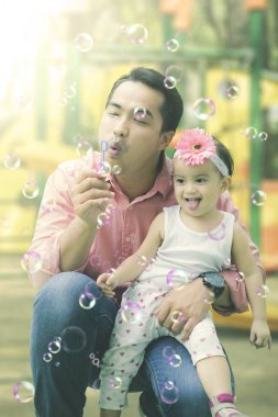 Mutlu kızı sabun köpüğü ile babası çalış.