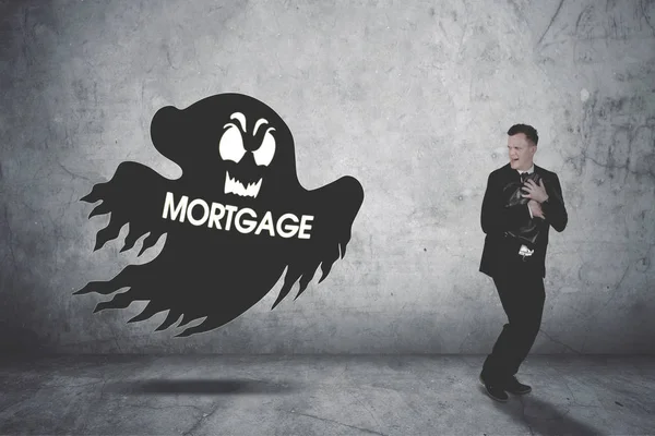 Empresário correndo susto sendo perseguido por um fantasma hipotecário — Fotografia de Stock