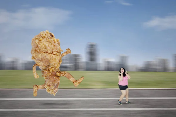 Ásia obesa mulher perseguido por um frito galinha — Fotografia de Stock