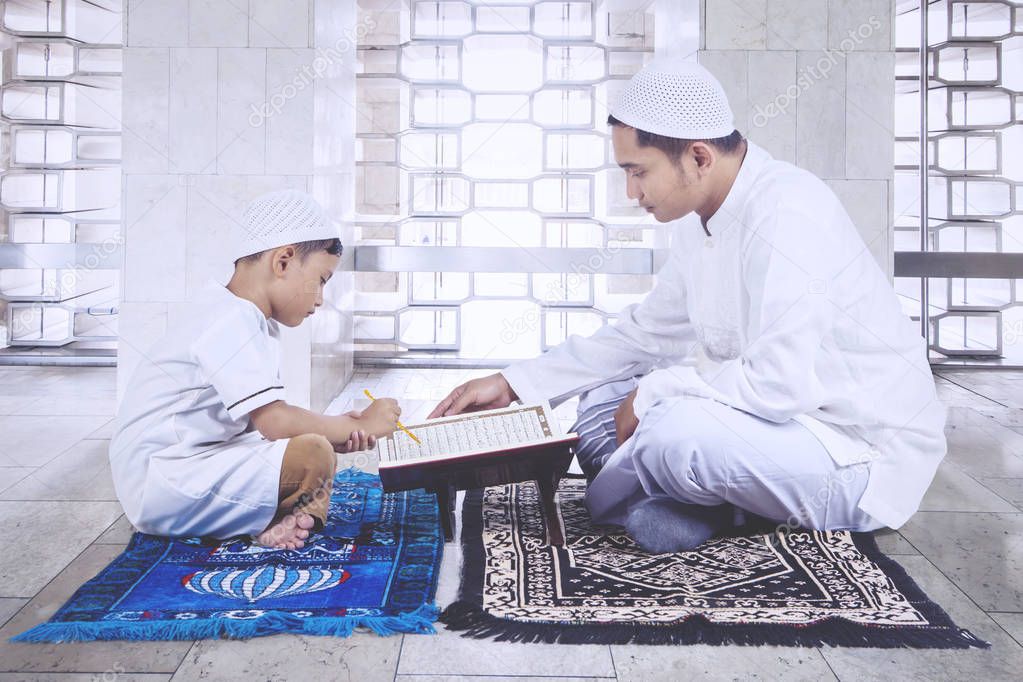 Muslim father and son praying in Istiqlal mosque