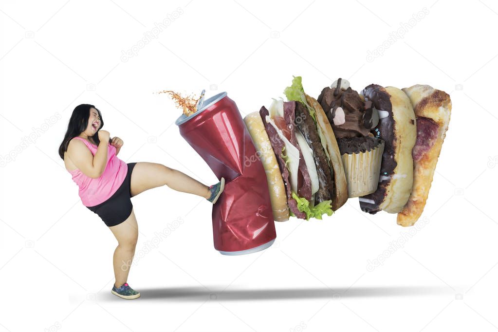 Fat woman kicking junk foods on studio