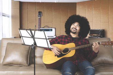 Müzisyen afro saçlı bir kayıt stüdyosunda gitar çalmak