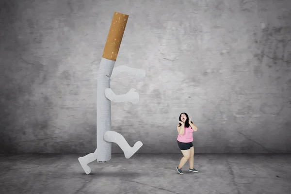 Otyłe kobiety jest ścigany przez papierosa — Zdjęcie stockowe