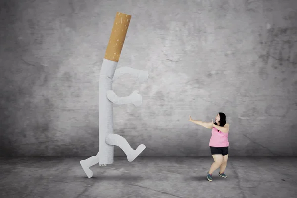 Толстая женщина убегает от сигареты — стоковое фото
