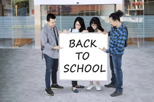 Gruppe von College-Studenten zeigt auf Whiteboard und sagt zurück in die Schule — Stockfoto