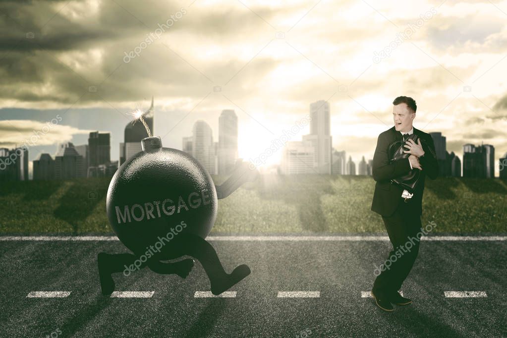 Caucasian businessman running away being chased by mortgage